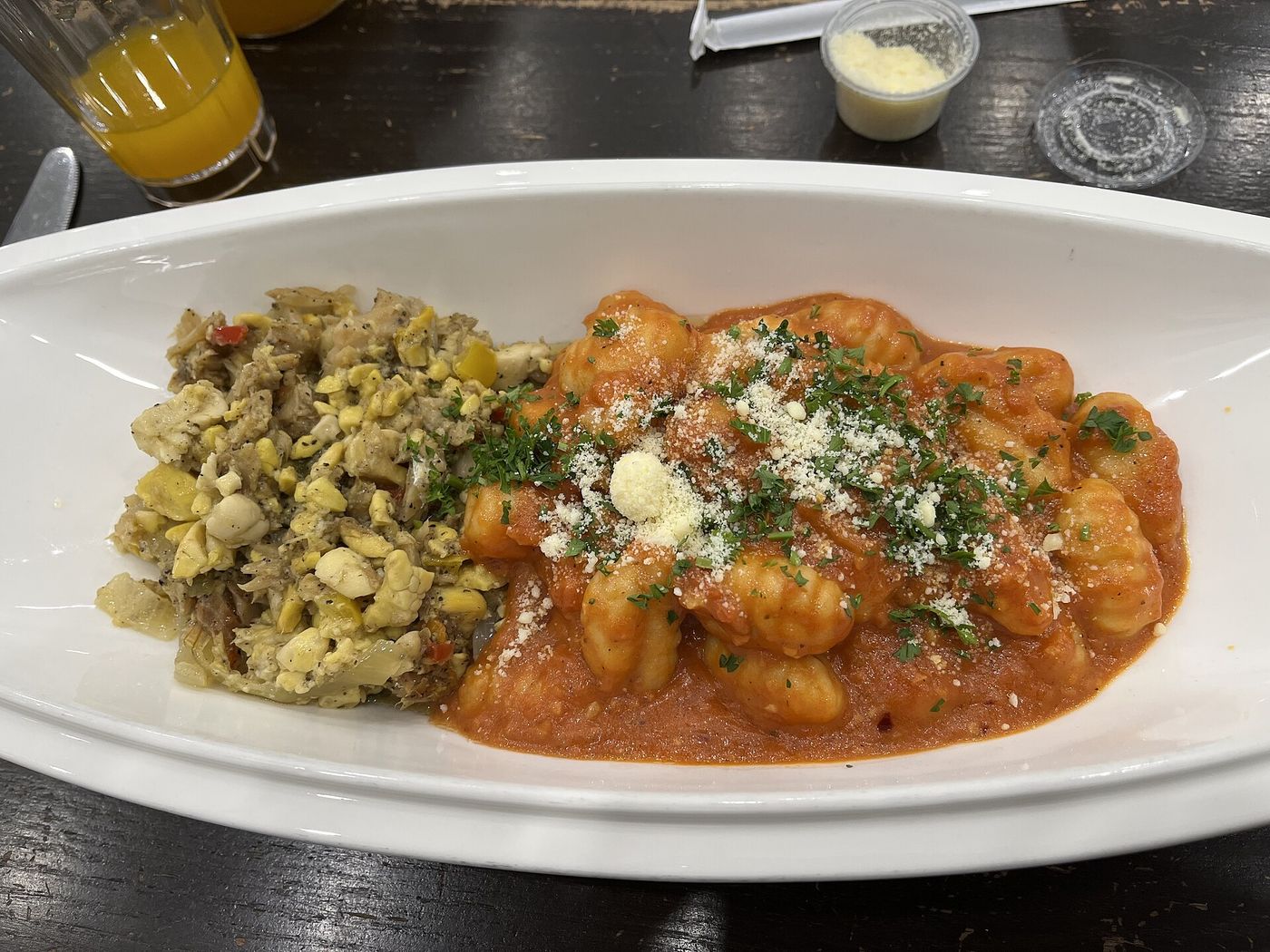Gnocchi in tomato butter, finished with grated cheese and herbs.